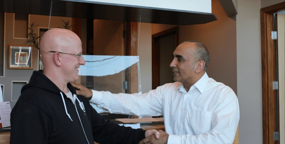 Dr. Madahar welcoming a patient at the clinic's front desk
