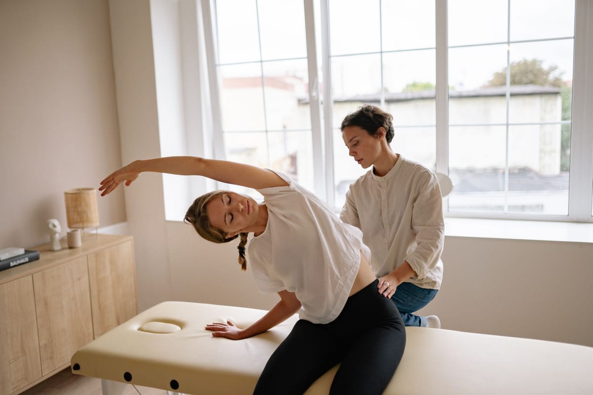 A clinician supporting a patient through a side stretch