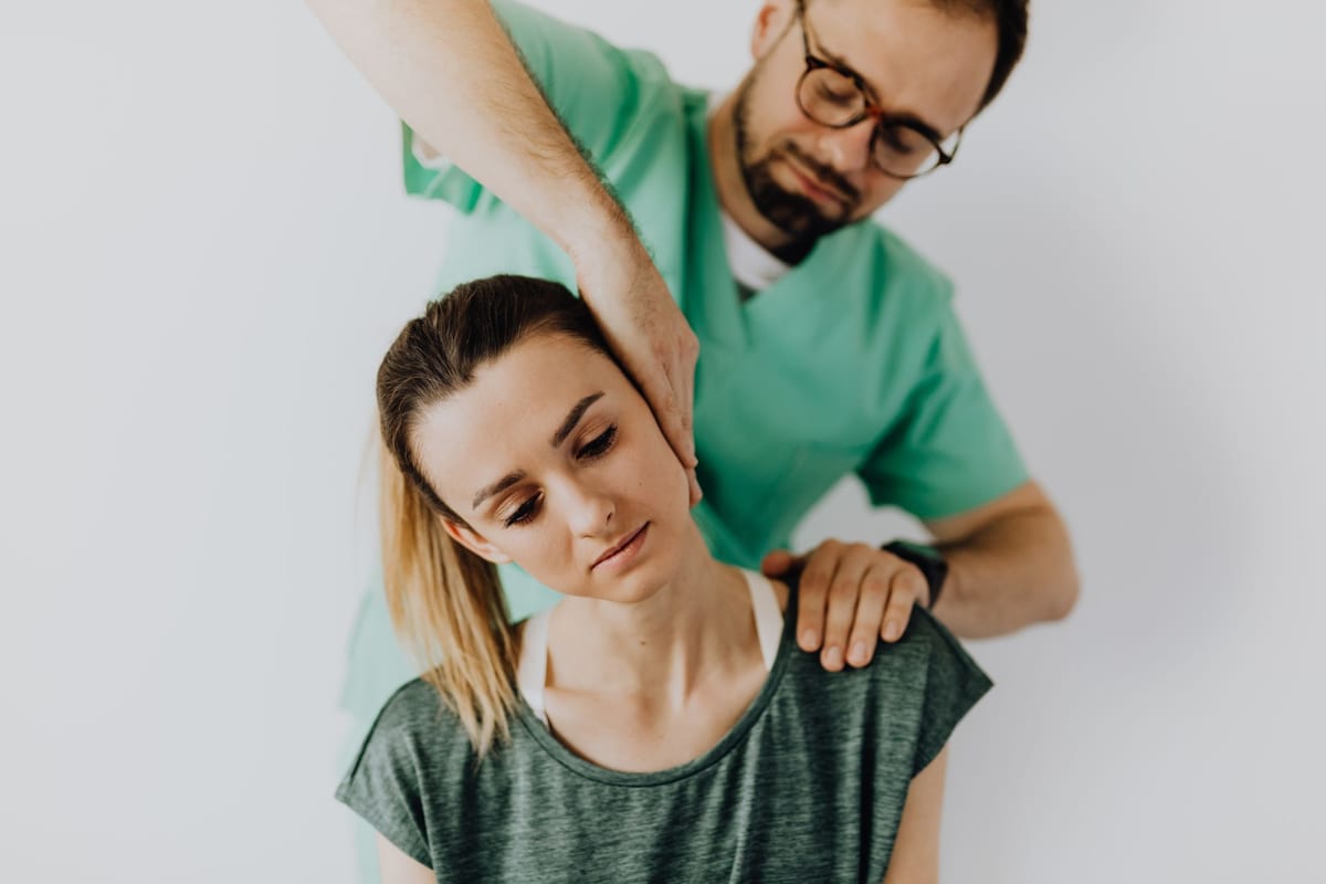 A clinician performing a gentle neck treatment on a patient